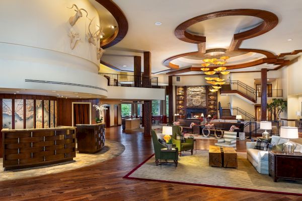 Elegant hotel lobby with modern decor, comfy seating, artistic lighting, and a warm ambiance.