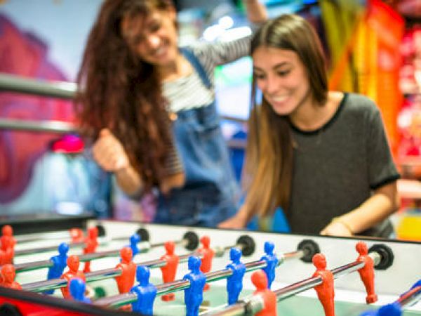 Two people are enjoying a game of foosball.