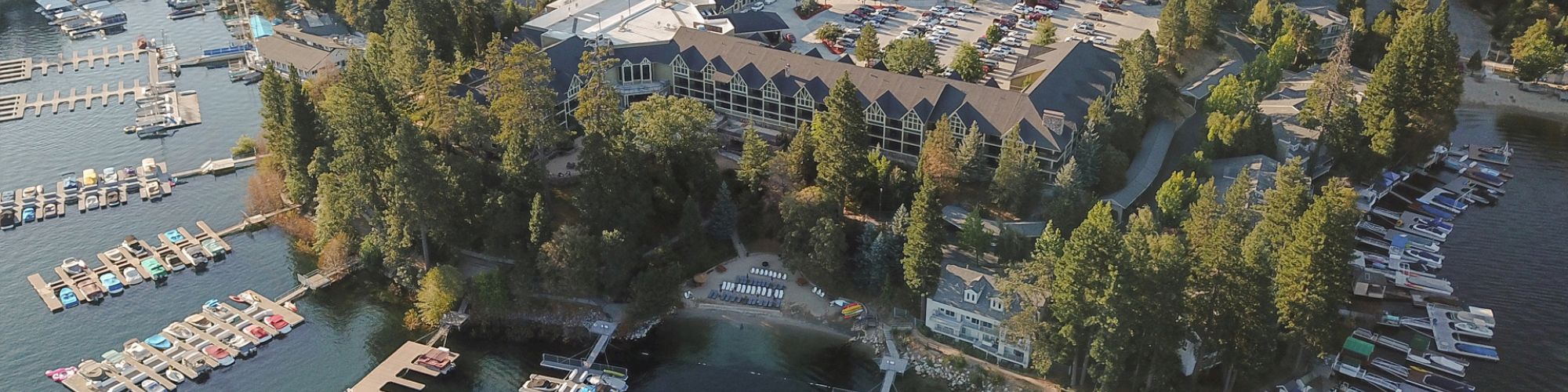 An ariel view of the resort showing the property surrounded by trees next to a lake filled with boating docks.