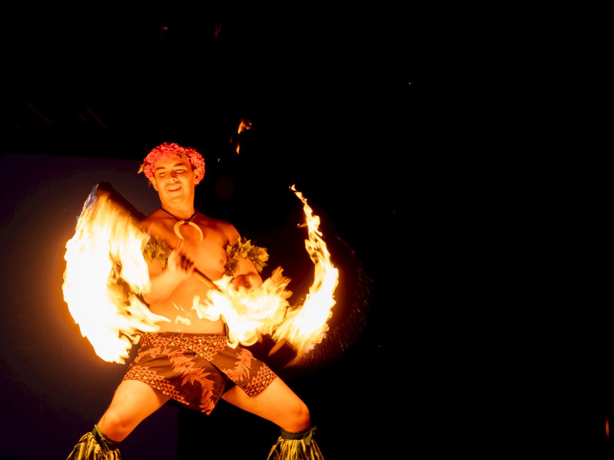 Person performing a fire dance dispay at night.