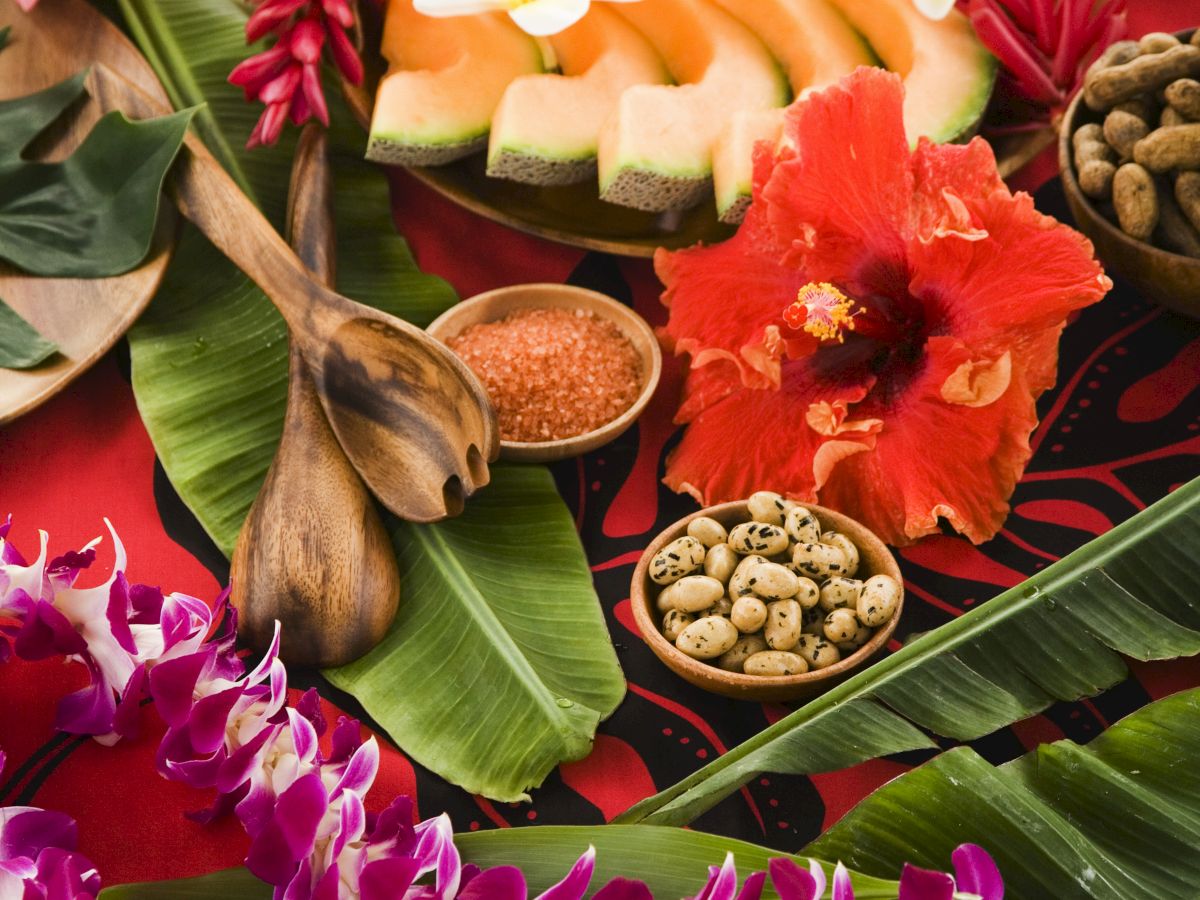 A table full of Hawaiian decorations such as fruit and flowers.