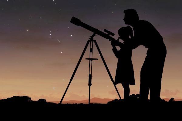 A silhouette of two people, one adult and one child, observing the night sky through a telescope against a sunset background.